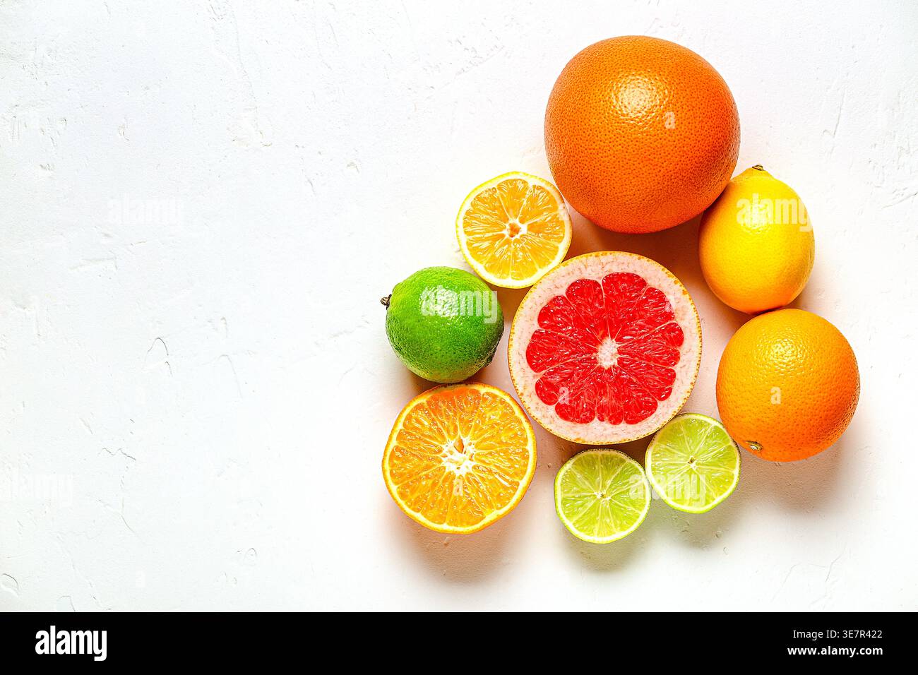 Citron frais, orange, pamplemousse, citron vert sur fond clair, vue de dessus. Concept de jus d'agrumes, vitamine C, fruits. Banque D'Images