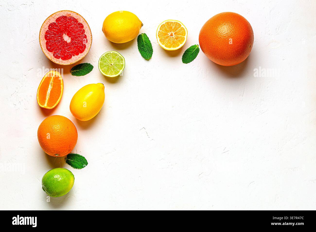 Citron frais, orange, pamplemousse, citron vert, feuilles vertes sur fond clair, vue de dessus. Concept de jus d'agrumes, vitamine C, fruits. Banque D'Images