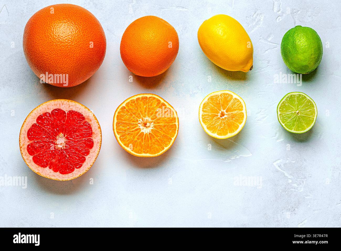 Citron frais, orange, pamplemousse, citron vert sur fond clair, vue de dessus. Concept de jus d'agrumes, vitamine C, fruits. Banque D'Images
