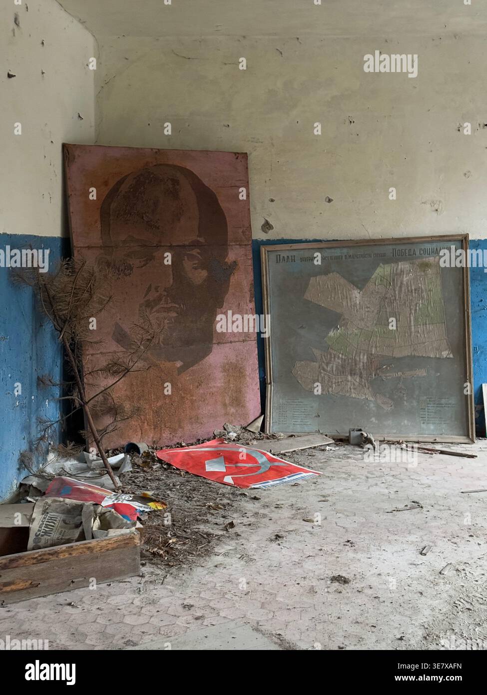 Intérieur soviétique abandonné avec portrait de Lénine et symboles communistes dans un bâtiment en décomposition Banque D'Images