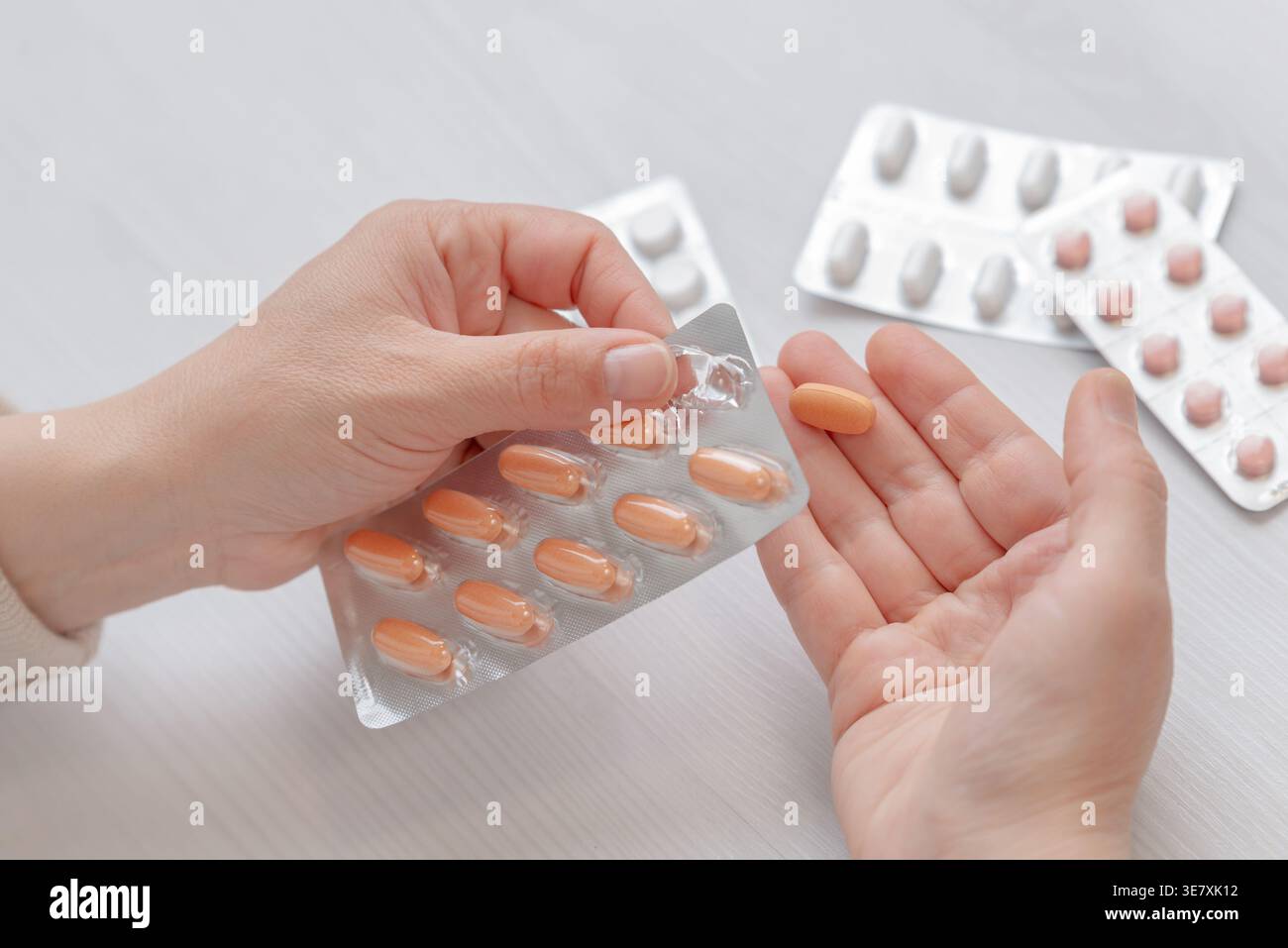 Gros plan de la main retirant la capsule de l'emballage blister, concept pharmaceutique et de soins de santé Banque D'Images