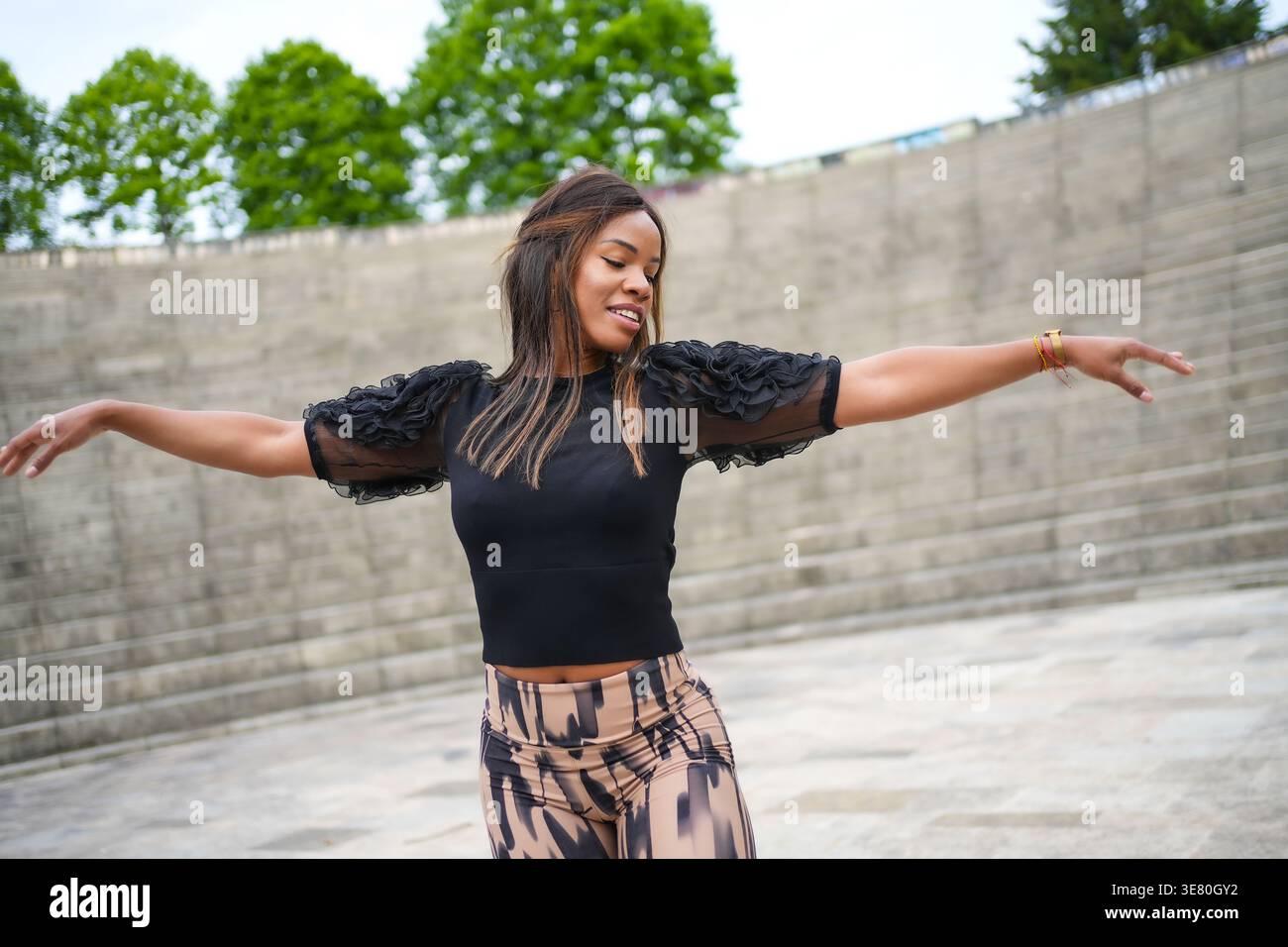 Femme hispanique à bras ouverts dansant la salsa cubaine dans le parc Banque D'Images