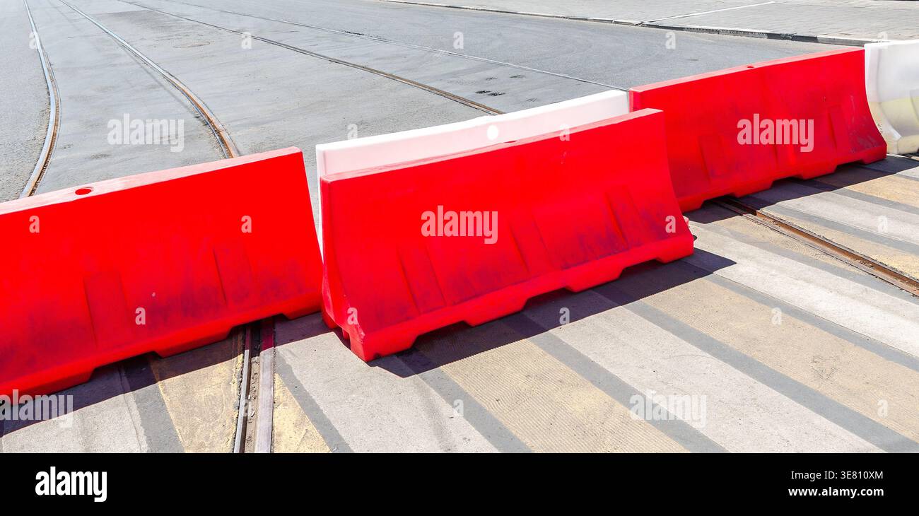 Barrières routières en plastique rouge, barrière routière dans la rue de la ville. Route en construction. Barrières de sécurité à la ville Banque D'Images