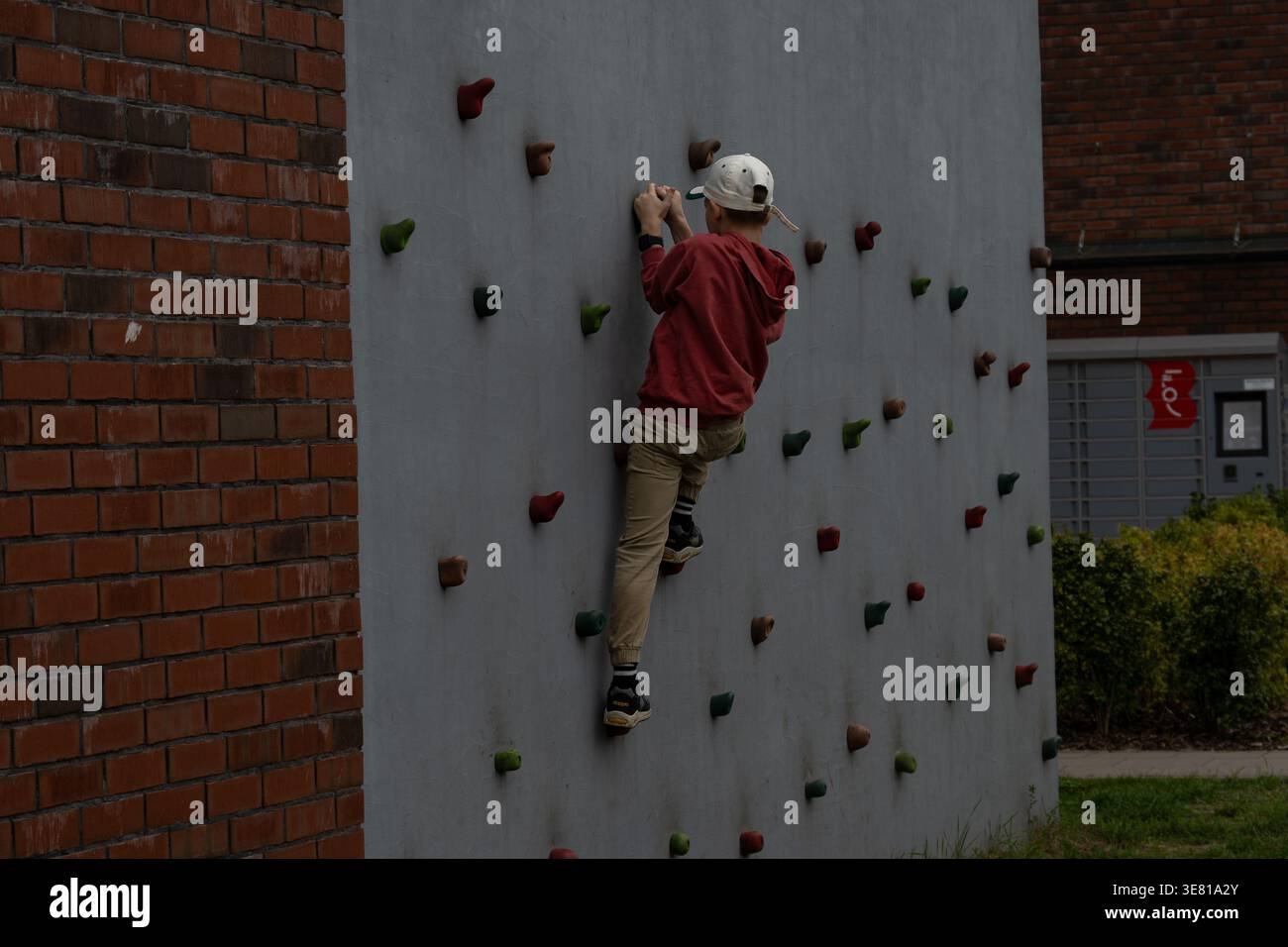 Enfants grimpant sur le mur d'escalade extérieur dans l'aire de jeux, loisirs actifs et activité physique, environnement urbain Banque D'Images