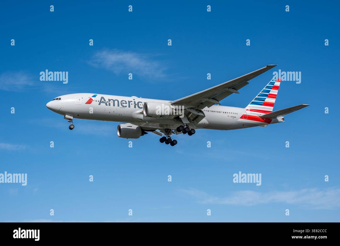 HEATHROW, Royaume-Uni, 17 MARS 2026 : atterrissage d'un Boeing 777-200 d'American Airlines en jet large contre un ciel bleu clair Banque D'Images