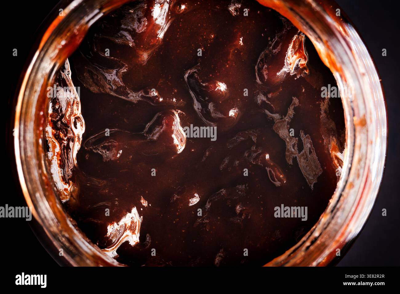 Confiture de prunes dans un pot ouvert vue de dessus – conservation de fruits maison en gros plan texture Banque D'Images