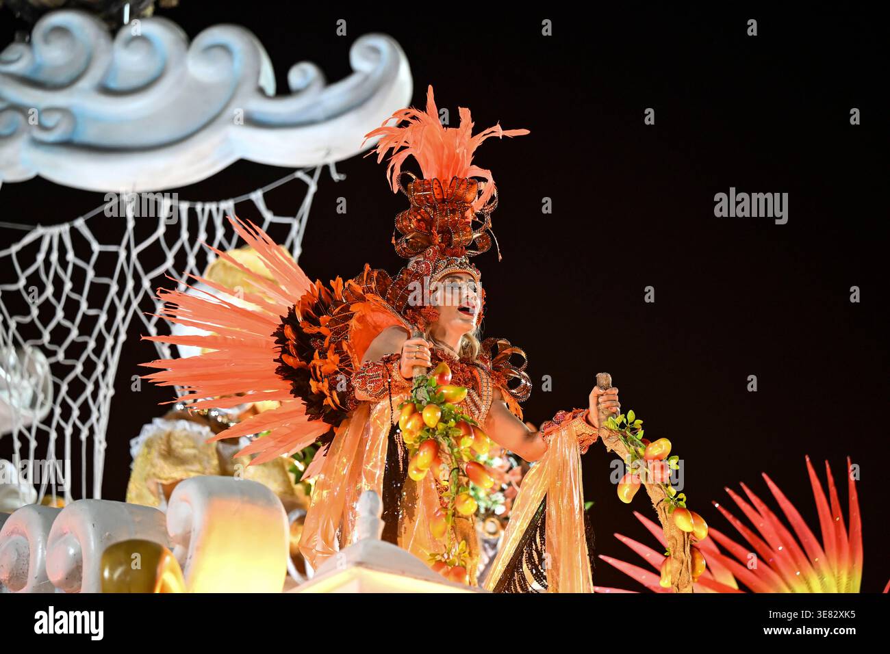 Rio de Janeiro, RJ-Brésil - 16 février 2026, Une femme vêtue d'un costume de carnaval orange et marron très détaillé, avec de grandes plumes et Banque D'Images