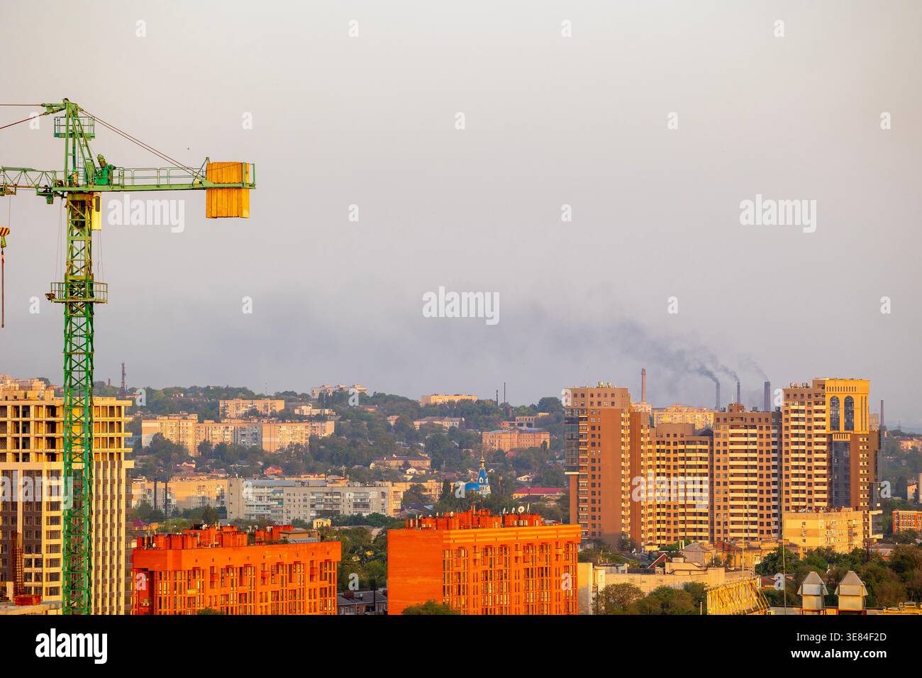 Dnipro, Ukraine ville skyline avec grue de construction imposante et bâtiments résidentiels modernes contre un ciel brumeux, mettant en valeur le développement urbain et di Banque D'Images