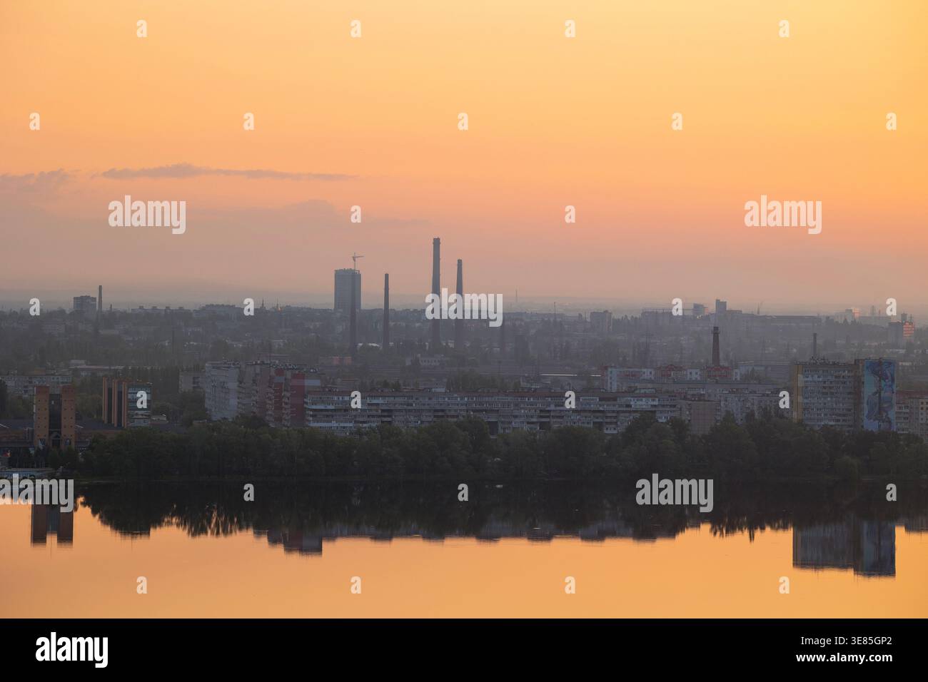 Dnipro, Ukraine – 19 mai 2023 : une vue aérienne du paysage urbain de Dnipro à l'aube, des cheminées industrielles, des bâtiments résidentiels et des lignes d'arbres reflétant Banque D'Images