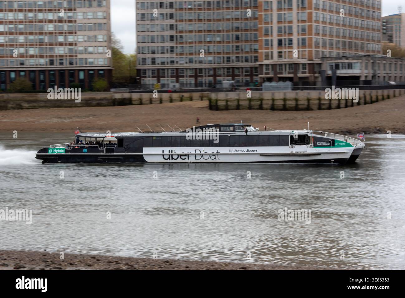 Un Thames Clippers (bateau Uber) sur la Tamise à marée basse, Londres, Royaume-Uni Banque D'Images