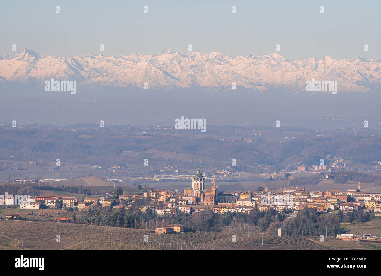 Vue matinale du village de Piamonte en Italie, entouré de collines ondulantes et de montagnes enneigées lointaines. Le paysage paisible capture l'essence Banque D'Images