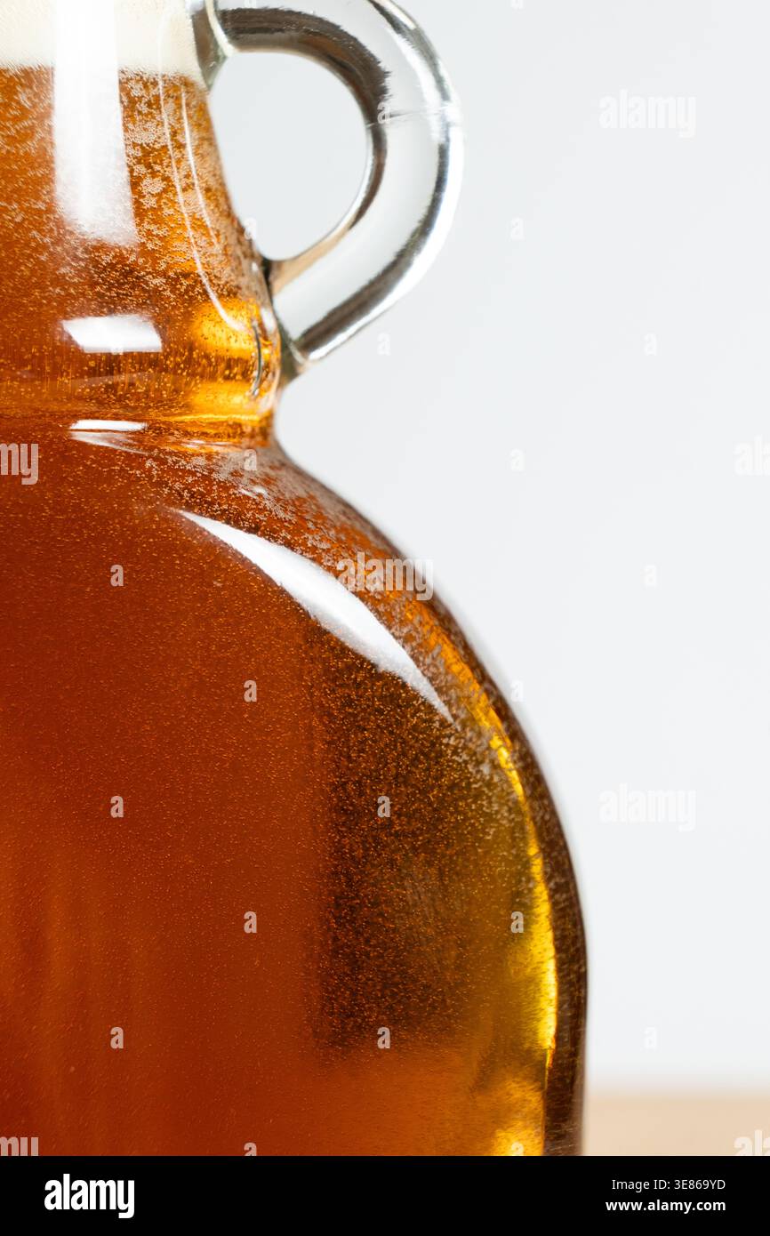 Gros plan du sirop d'érable doré dans une bouteille en verre. Banque D'Images