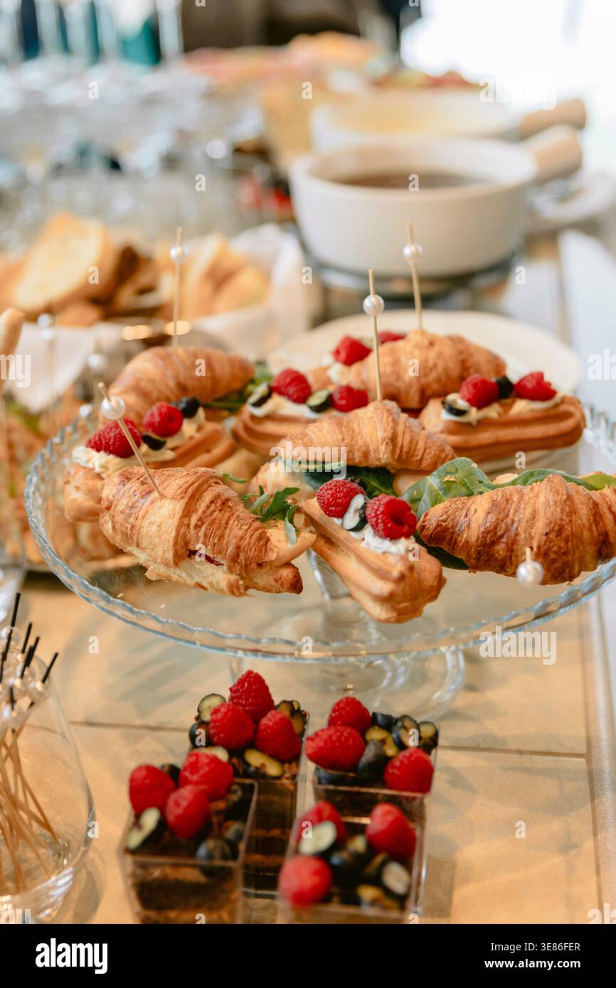 Table de restauration élégante avec croissants, desserts et baies fraîches pour buffet festif ou brunch Banque D'Images
