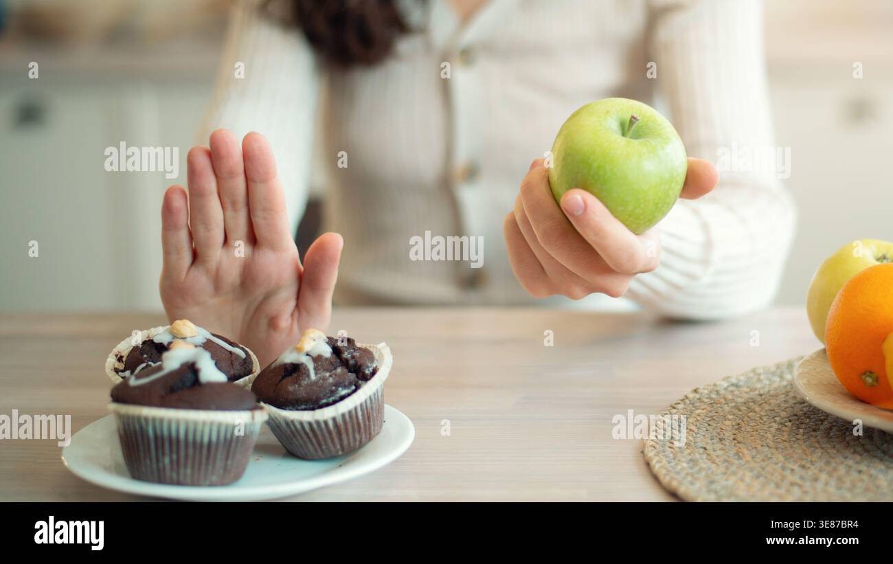 Faire des choix sains avec des fruits et des desserts à une table de cuisine le matin Banque D'Images
