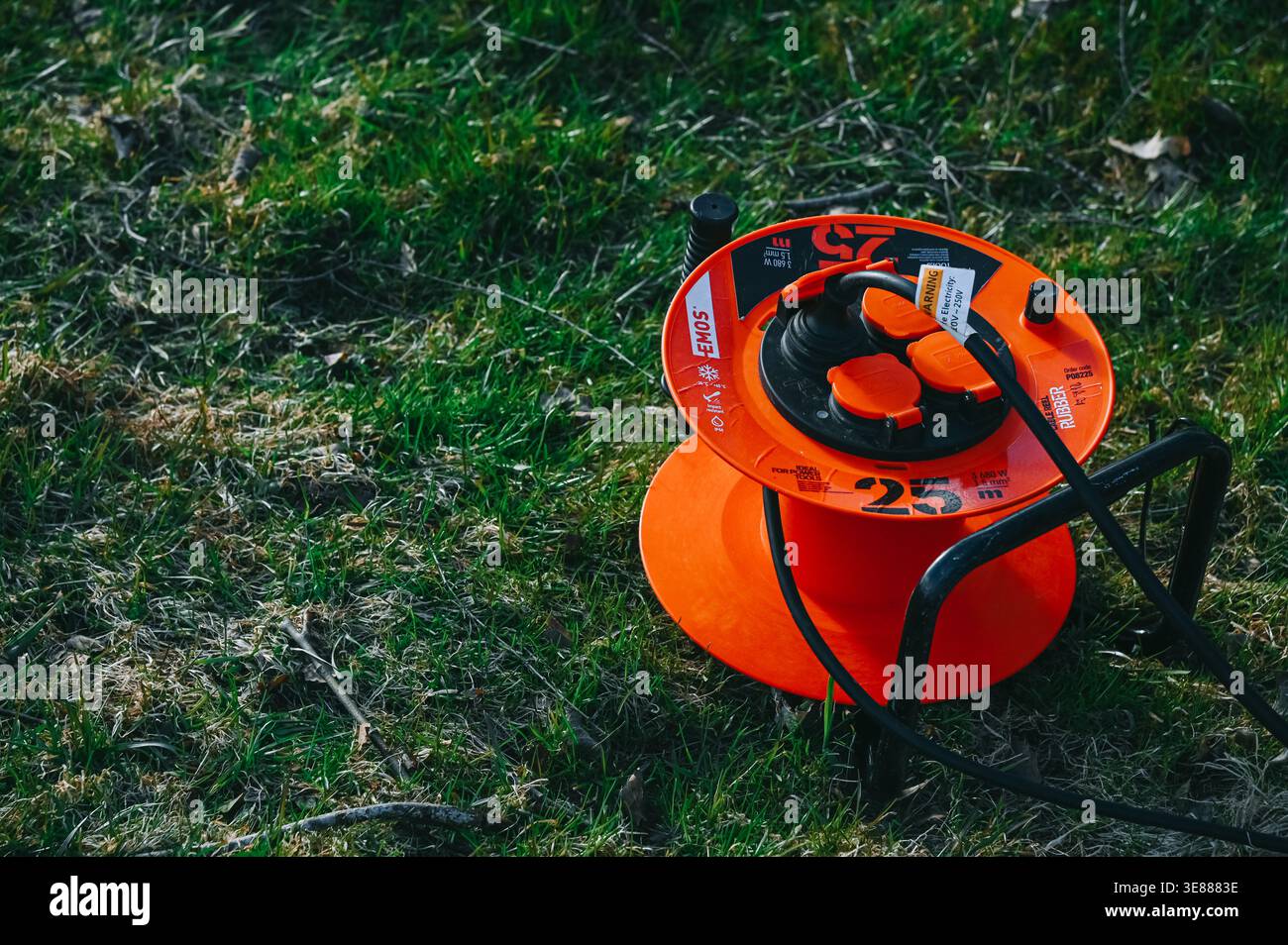 Riga, Lettonie - 11 avril 2026 : bobine de câble d'extérieur portable avec plusieurs prises de courant placées sur l'herbe. Idéal pour les travaux de jardin, la construction et la maison i. Banque D'Images