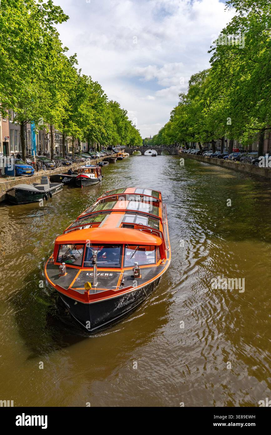Bateau touristique naviguant sur un canal à Amsterdam Banque D'Images