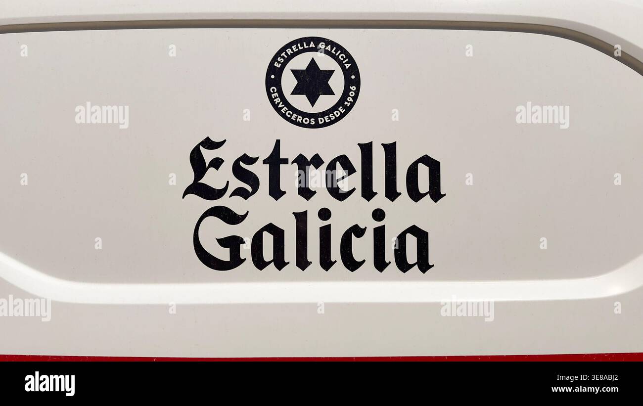 Logo de la marque de bière espagnole Estrella Galicia imprimé sur le côté blanc d'un véhicule de livraison commercial - Image de stock capturée avec un smartphone