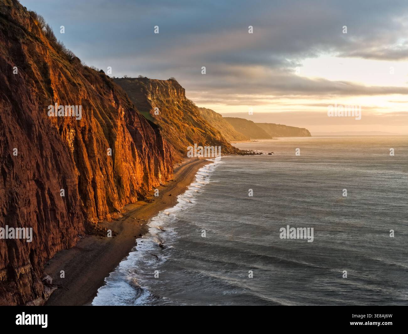 Vue aérienne par drone des anciennes falaises rouges du Trias de Sidmouth au lever du soleil, côte est du Devon, regardant vers l'ouest le long de la côte jurassique, Angleterre, Royaume-Uni. Banque D'Images