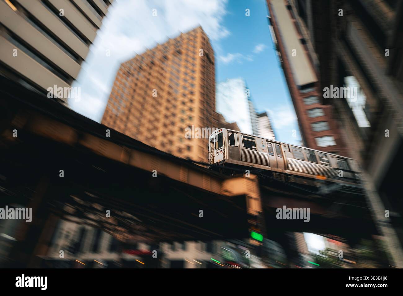 Train des transports publics en mouvement sur le chemin de fer surélevé au-dessus de la rue dans le centre-ville de Chicago. Transports urbains, vie urbaine, infrastructures et quotidien Banque D'Images