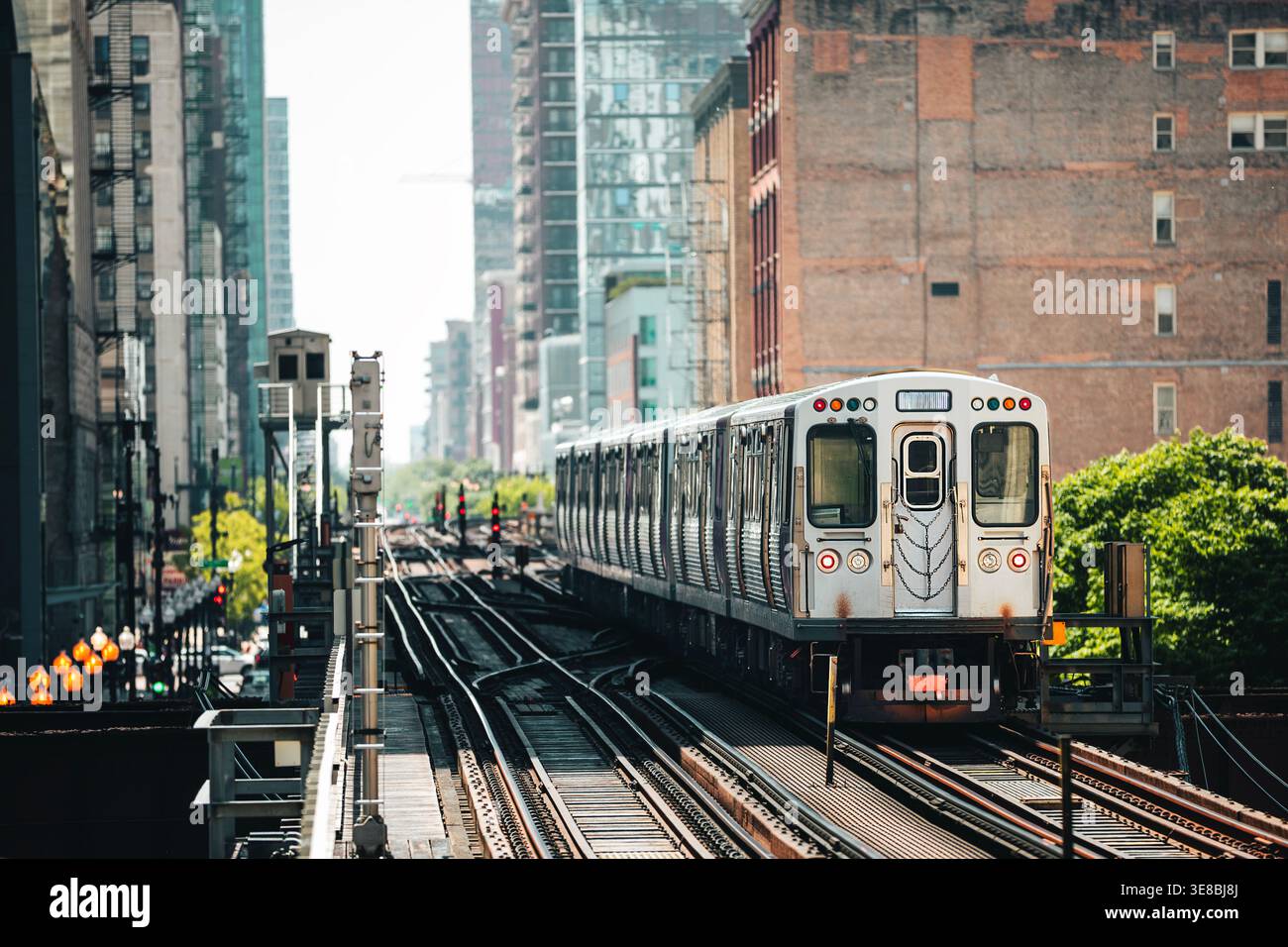 Train des transports en commun arrivant sur le chemin de fer surélevé au-dessus de la rue animée dans le centre-ville de Chicago. Transports urbains, vie urbaine, infrastructures et dai Banque D'Images