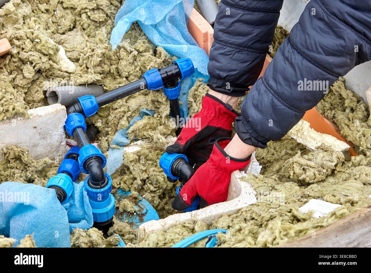 Réparation de la tuyauterie de distribution en PEHD chez le propriétaire de puits artésien utilisant des raccords de compression pour connecter les sections de tuyau. Banque D'Images