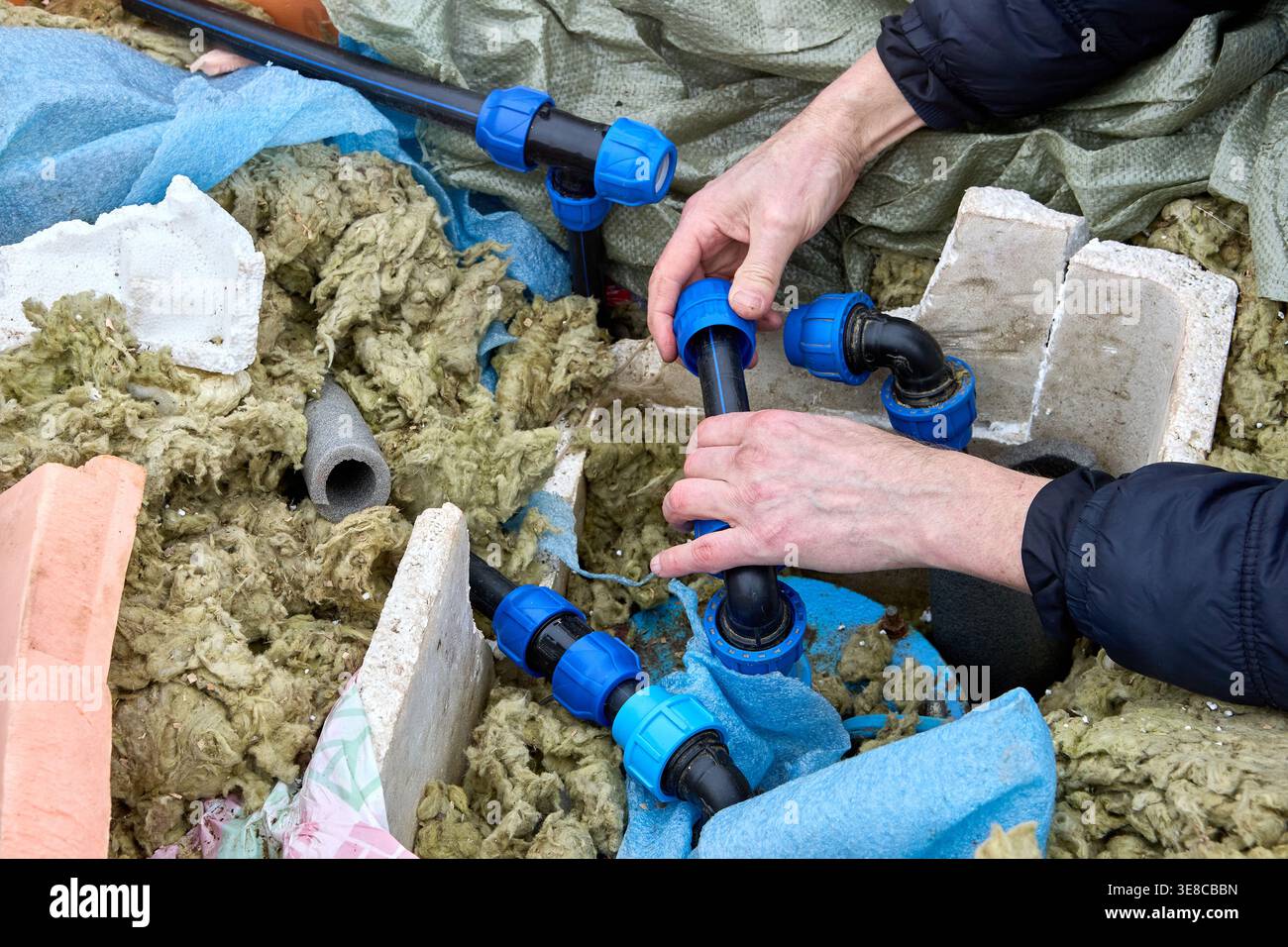 Entrepreneur de puits réparant la tuyauterie de distribution d'eau de puits. Banque D'Images