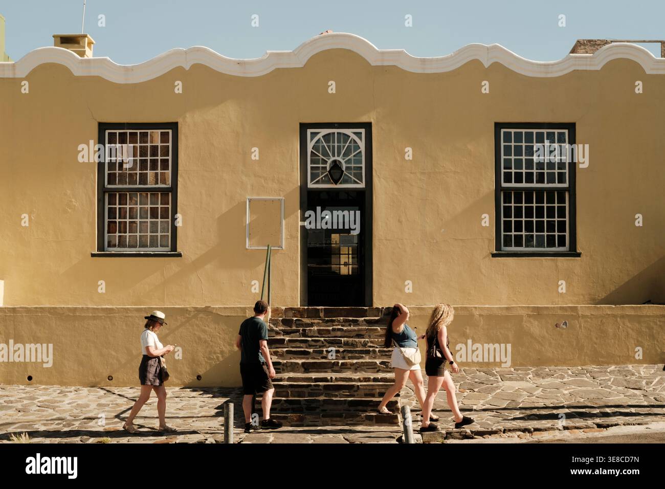 Touristes passant devant l'entrée du musée Iziko Bo-Kaap au Cap, en Afrique du Sud. Une des premières maisons construites par Jan de Waal en 1768. Banque D'Images
