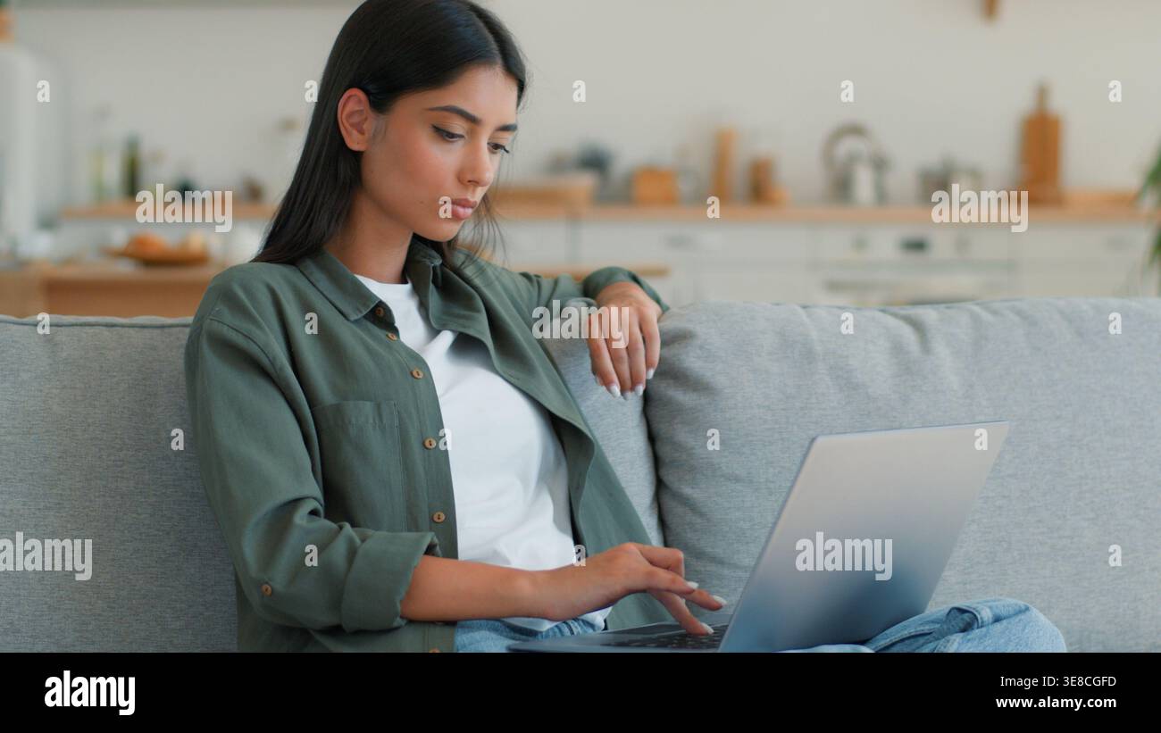 Sérieuse femme indienne concentrée travaillant à étudier en ligne dactylographiant ordinateur portable à la maison regardant loin pensant méditer femme arabe auteur écrivant PC Banque D'Images