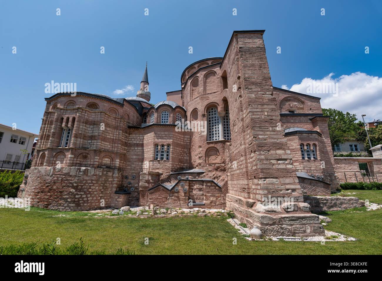 Extérieur de la Mosquée historique Kariye, anciennement église Chora, une structure byzantine en brique rouge avec minaret et dômes sous un ciel bleu à Istanbul, Turquie Banque D'Images