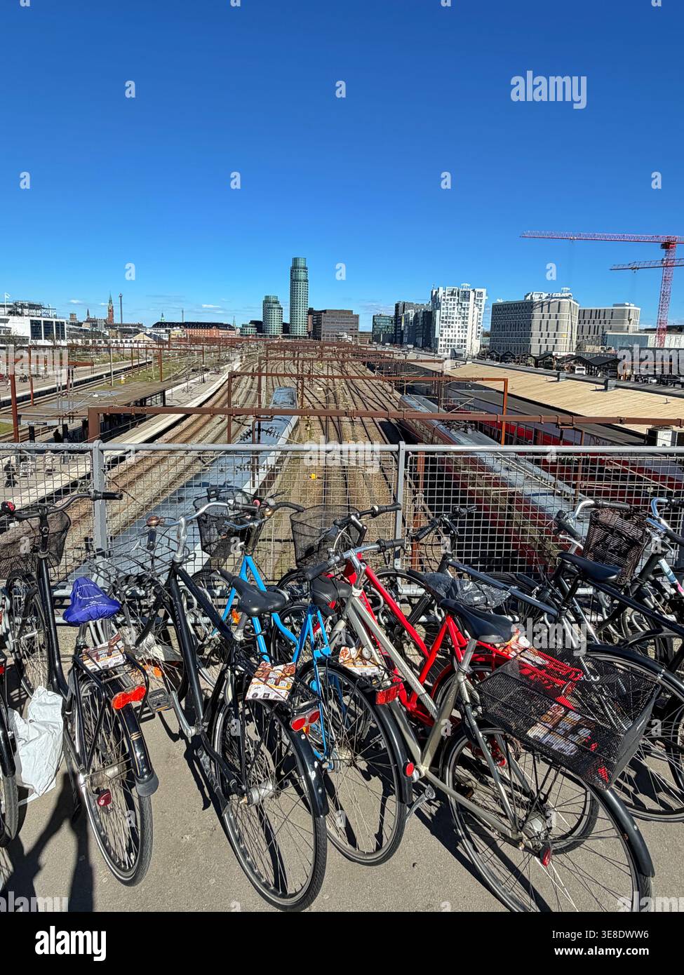 Vélos garés sur un pont au-dessus de la gare de Dybbølsbro, Copenhague. Tours Axel au loin. Banque D'Images