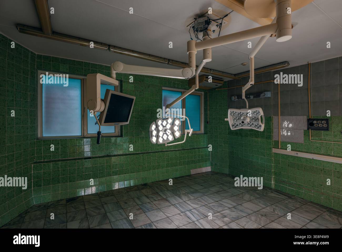 Salle chirurgicale équipée de deux lampes LED, d'un bras de moniteur et de fenêtres givrées. Un environnement médical stérile et moderne préparé pour les pros chirurgicaux Banque D'Images