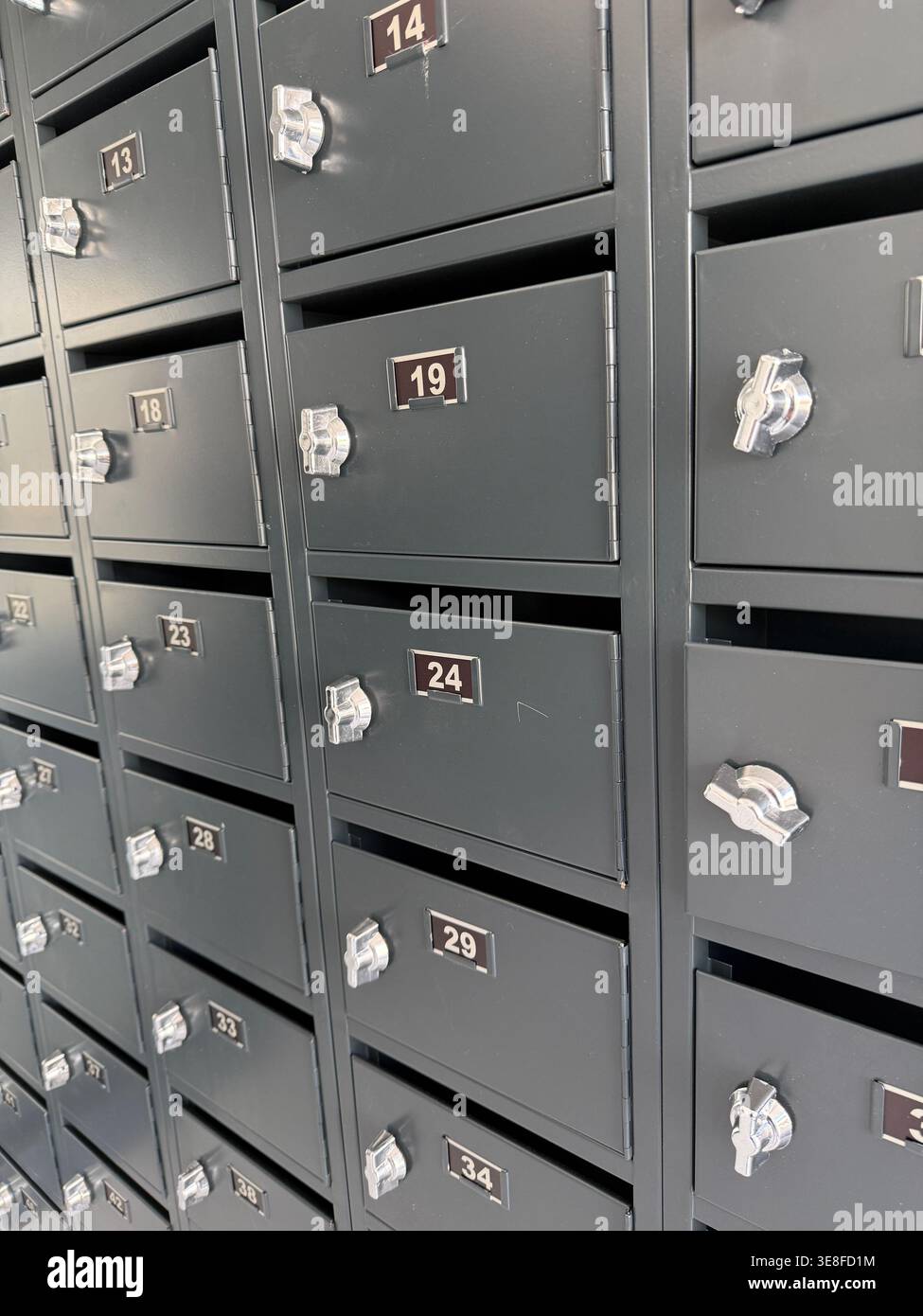 Boîtes aux lettres dans une rangée avec étiquettes numérotées, idéal pour le concept de service postal ou arrière-plan. Photo mobile Banque D'Images