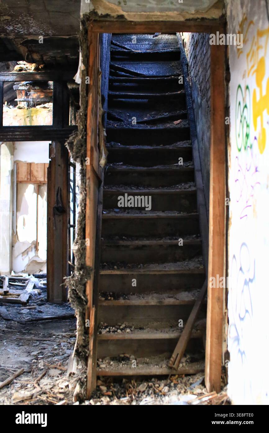 Escalier abandonné à l'intérieur d'un bâtiment détérioré avec des murs de graffiti. Banque D'Images