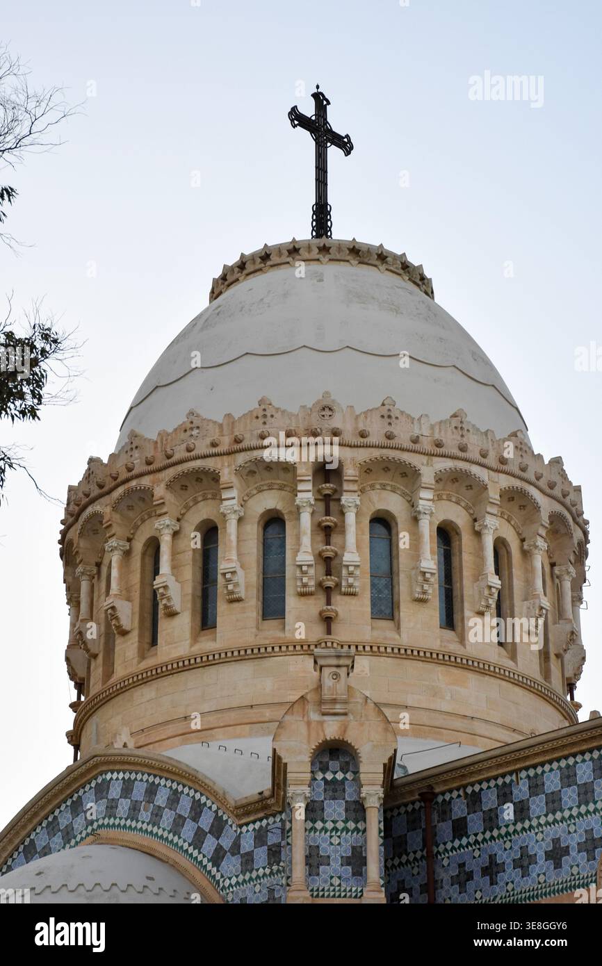Détail architectural en gros plan du dôme en pierre blanche et de la croix de fer proéminente de la basilique notre-Dame d'Afrique à Alger, Algérie. Banque D'Images