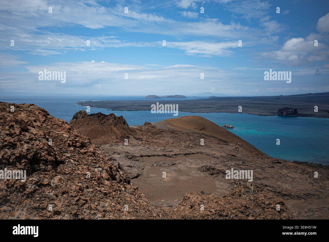 Vue surélevée depuis l'île de Bartolome dans les Galapagos montrant un terrain volcanique et des baies turquoises sous un ciel bleu. Banque D'Images