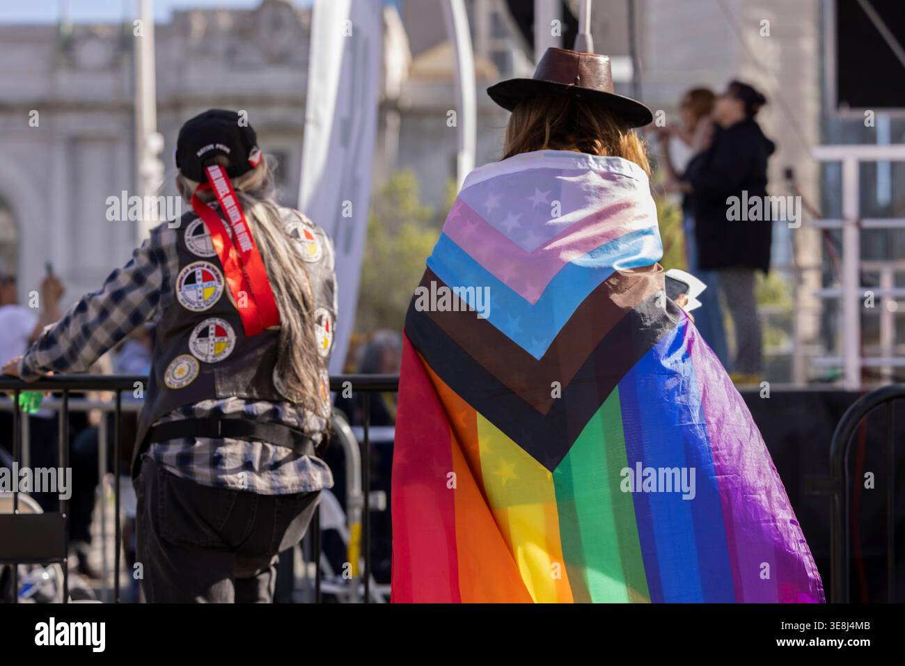 San Francisco, Californie, États-Unis - 28 mars 2026 : une personne enveloppe son corps dans un drapeau LGBTQ inclusif lors du troisième rassemblement No Kings. Banque D'Images