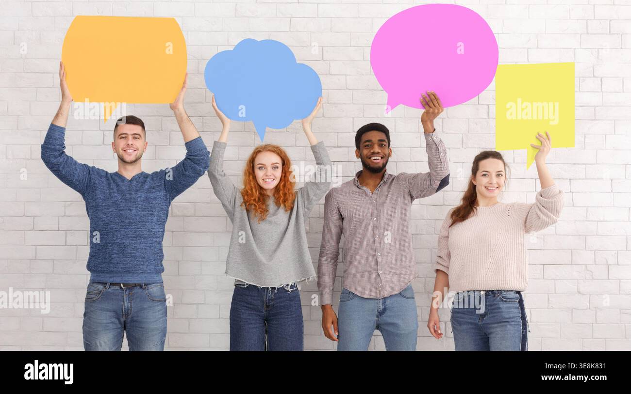 Groupe de quatre personnes tenant des bulles de parole colorées dans un cadre de Studio créatif Banque D'Images
