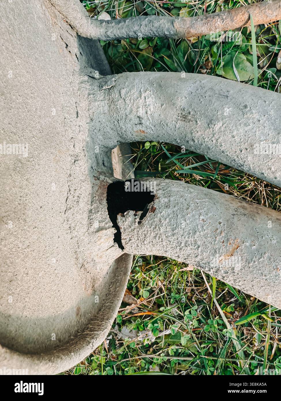 Gros plan d'une structure métallique détériorée avec un trou de rouille visible et des dommages dus à la corrosion dans un environnement extérieur. Idéal pour les concepts d'infrastructure d Banque D'Images