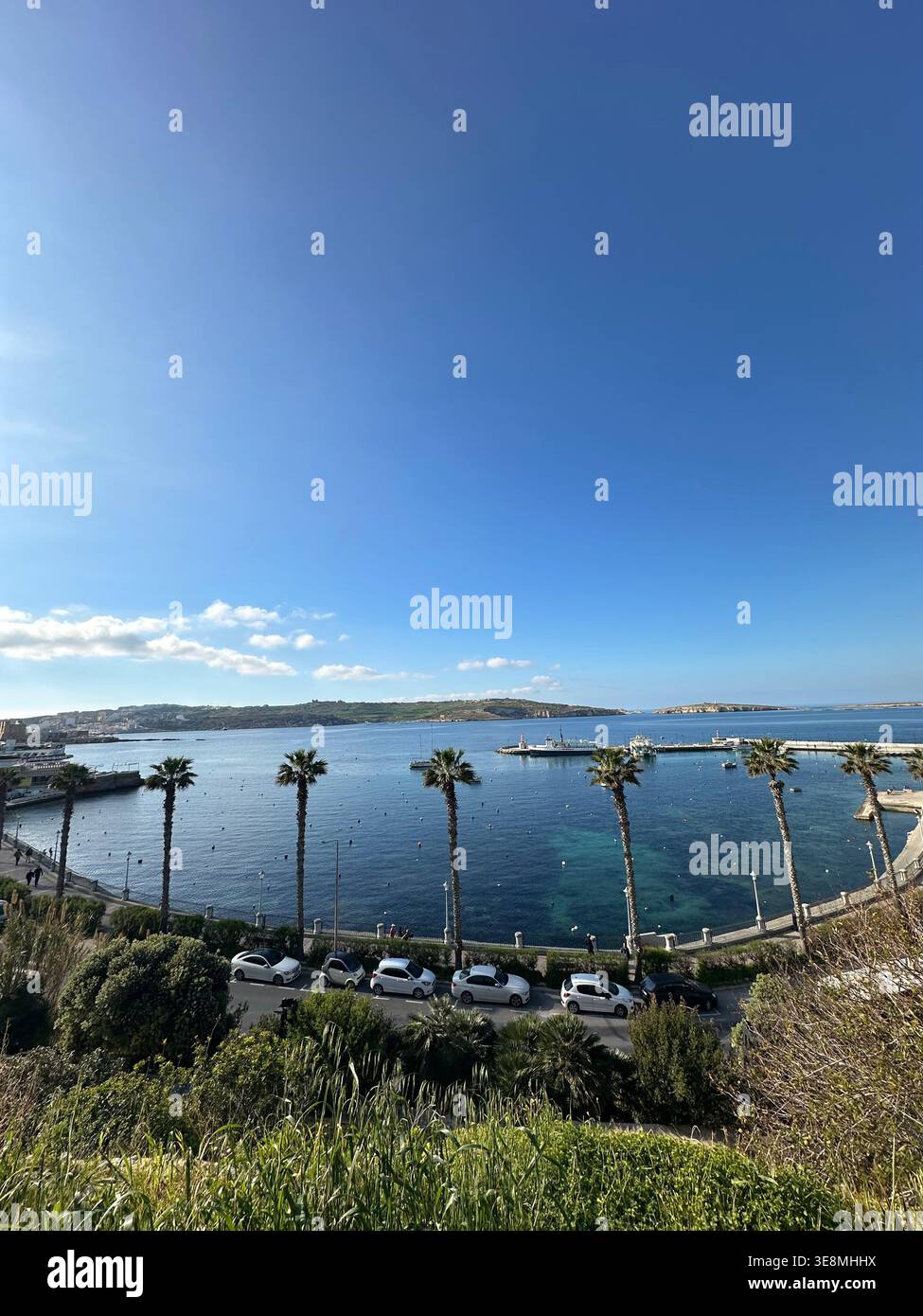 Vue panoramique sur la baie de St Paul à Malte avec des palmiers, mer Méditerranée bleue claire et paysage côtier sous un ciel ensoleillé lumineux, populaire européen - Image de stock capturée avec un smartphone