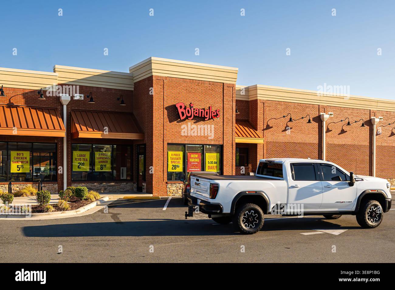 Une camionnette traverse le parking d'un restaurant Bojangles à Wendell, reflétant le transport quotidien et l'activité des consommateurs. Banque D'Images
