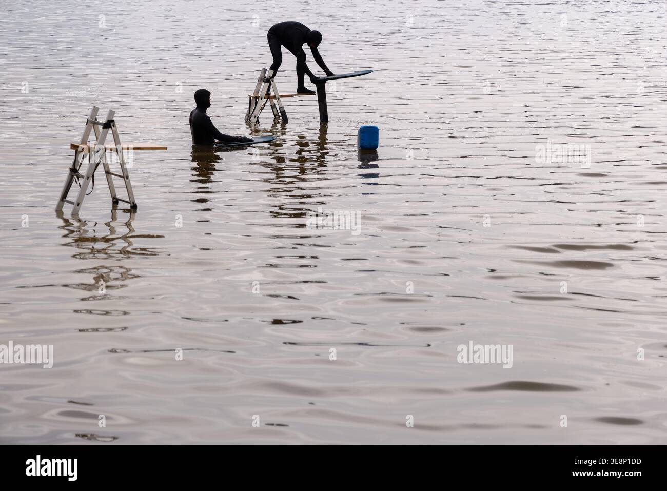 Homme chevauchant planche de surf dans des conditions d'eau calme près de Madrid, Espagne. Banque D'Images
