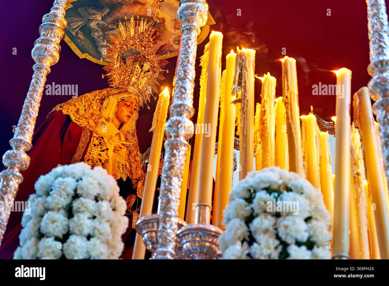 Les gens se rassemblent pour une procession de Pâques à Malaga, Andalousie. L'événement comprend des bougies, des décorations et une statue transportée dans les rues. Banque D'Images