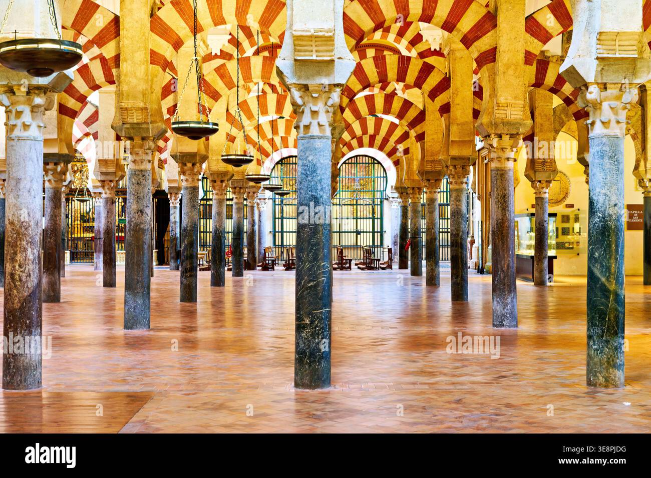 Les gens explorent la Mezquita à Cordoue, en Espagne. Le célèbre site présente de grandes arches et des colonnes dans son hall principal pendant les heures de lumière du jour. Banque D'Images