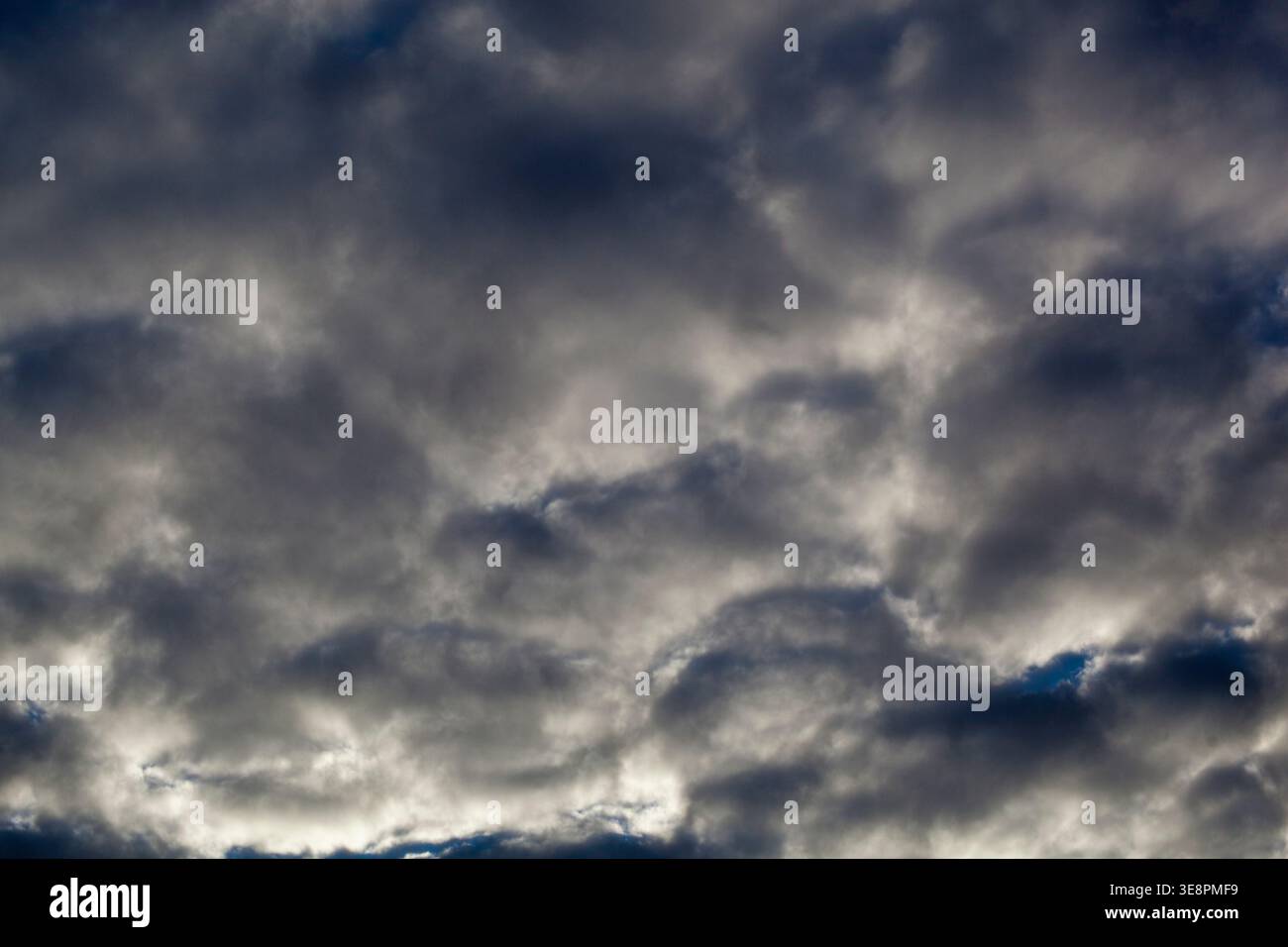 Des nuages sombres remplissent le ciel au-dessus de la ville alors qu'une tempête approche apporte un temps inquiétant en fin d'après-midi. L'atmosphère semble lourde et chargée w Banque D'Images