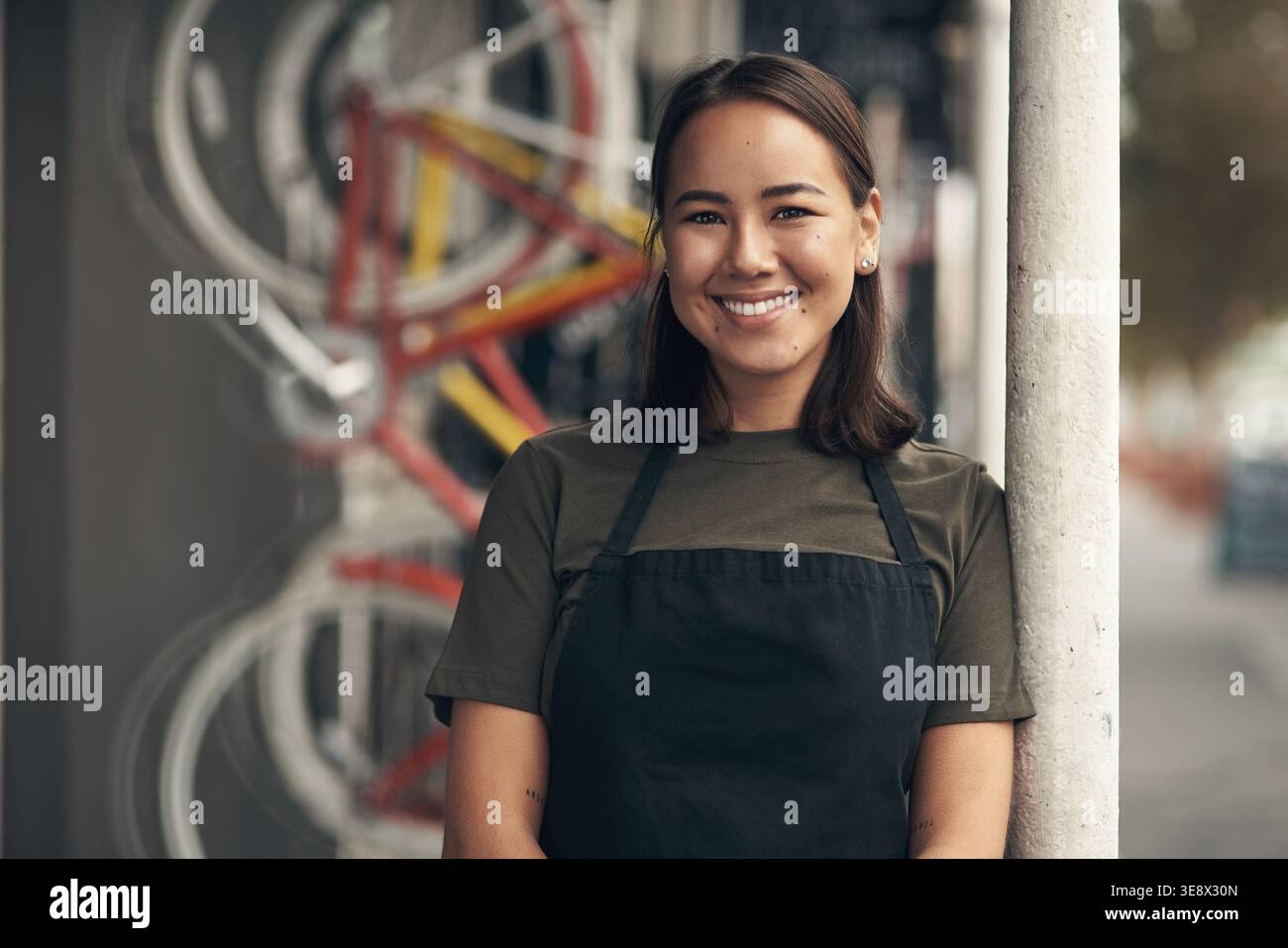 Mécanicien, portrait et femme heureuse dans un atelier de réparation de vélos, petite entreprise et entretien des transports. Confiant, entrepreneur et personne avec tablier pour Banque D'Images