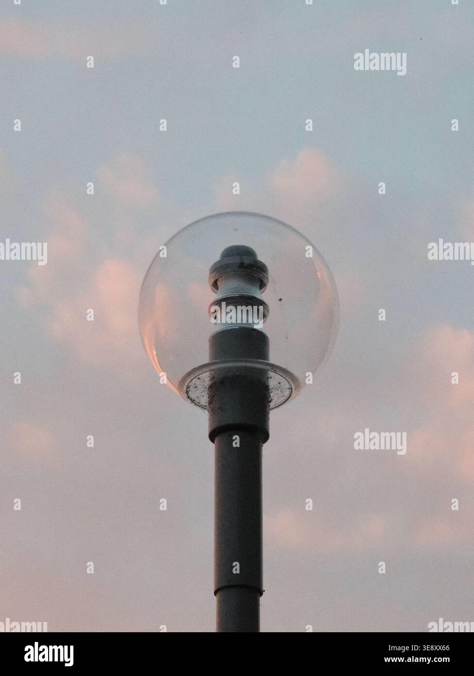 Un lampadaire globe minimaliste le long du remblai du Rhin de Düsseldorf, silhouetté contre un ciel nocturne doux près de la rivière. Banque D'Images