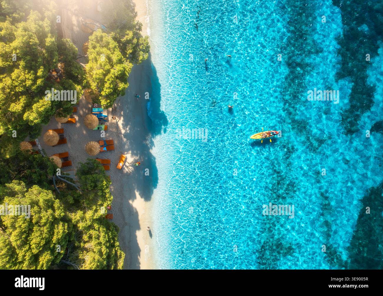 Vue aérienne de kayak, mer bleue, plage de sable, arbres et parasols Banque D'Images