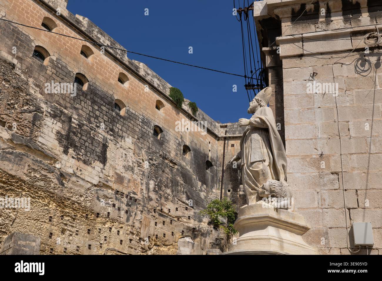 Mur du Fort Lascaris et statue Publius au coin de la Custom House à la Valette, Malte. Banque D'Images