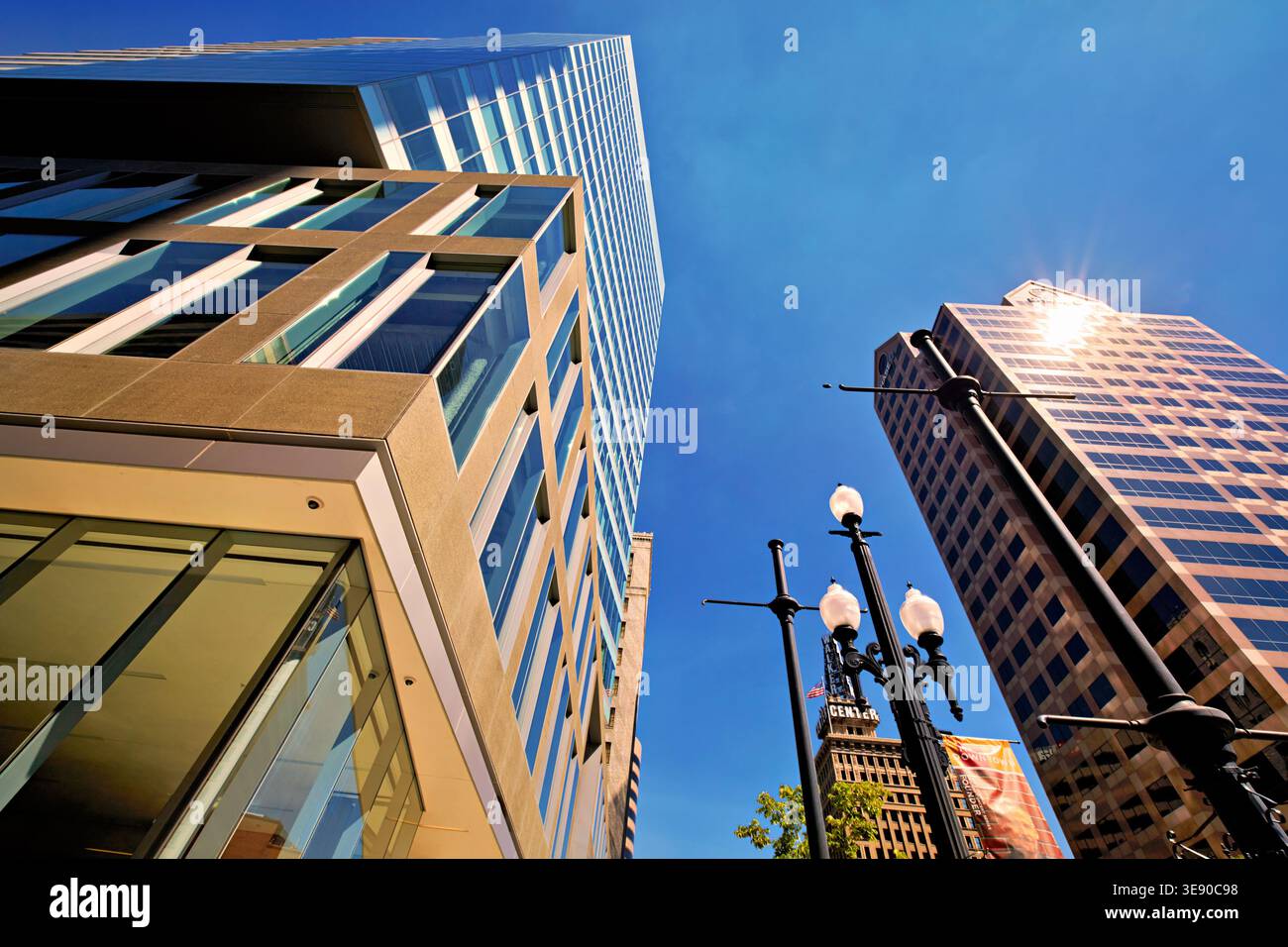 De grands bâtiments s'élèvent à Salt Lake City sous un ciel bleu clair. La lumière du soleil se reflète sur les surfaces vitrées créant des points lumineux. Banque D'Images
