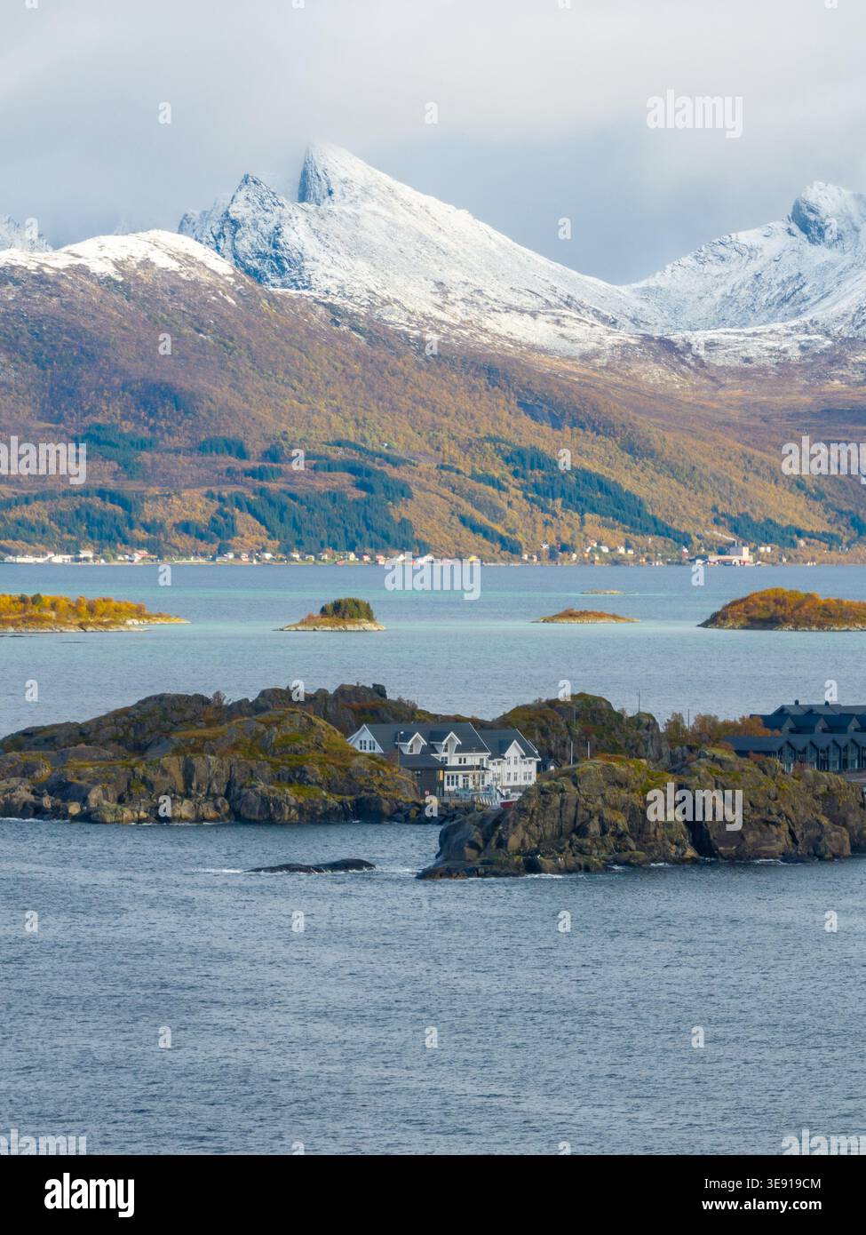 Vue aérienne de la station Hamn i Senja sur des îles rocheuses avec des montagnes enneigées et du feuillage d'automne à Skaland, Troms, Norvège. Banque D'Images